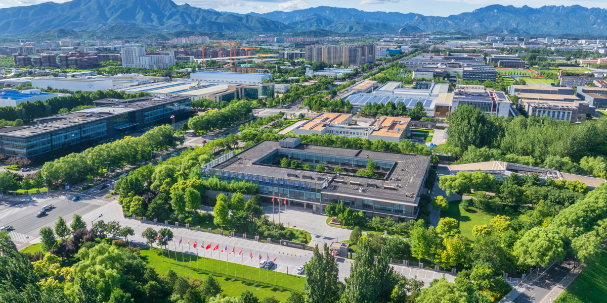 Budynek przemysłowy wśród drzew, widziany z lotu ptaka.