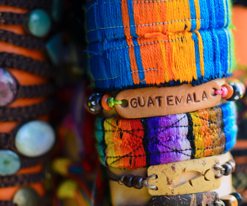 Kolorowe bransoletki na nadgarstku, w tym jedna z napisem Guatemala