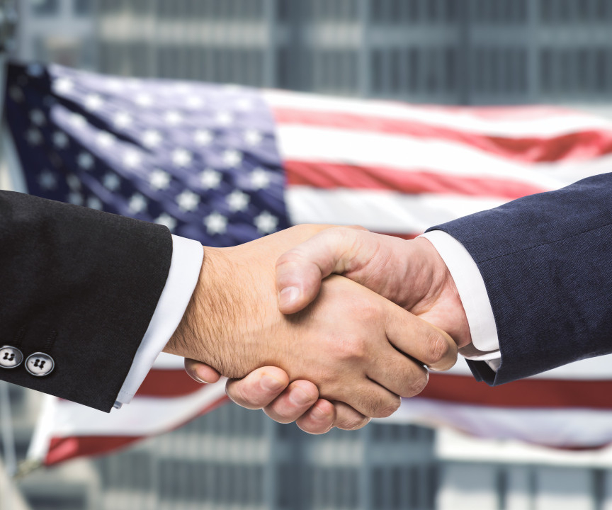 Uścisk dłoni na tle flagi USA