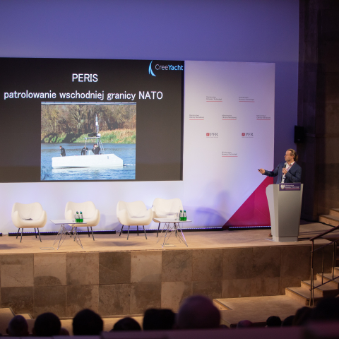 Widok sceny na konferencji i występującego mężczyzny