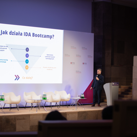 Mężczyzna przemawiający na scenie podczas konferencji